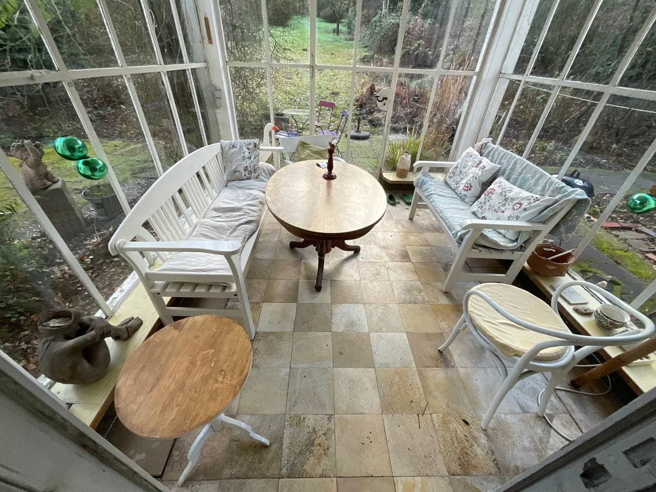 Wintergarten mit Korbmöbeln und Tischen vor der Einschätzung